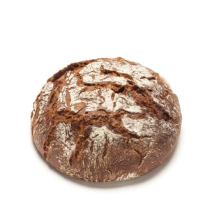 Ein runder, rustikaler Brotlaib mit einer knusprigen, braunen Außenseite und einer Mehlschicht auf der Oberseite, vor einem weißen Hintergrund.