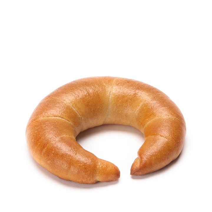 Ein einfaches, halbmondförmiges Brötchen mit goldbrauner Kruste ist vor einem weißen Hintergrund abgebildet.