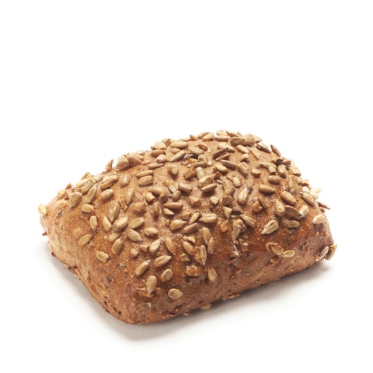Ein rechteckiges Stück Vollkornbrot, belegt mit Sonnenblumenkernen, isoliert auf weißem Hintergrund.