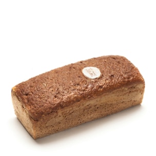 Ein rechteckiger Laib Schwarzbrot mit einer leicht strukturierten Kruste liegt auf einem weißen Hintergrund. Ein kleines rundes Etikett befindet sich oben auf dem Brot in der Nähe eines Endes.