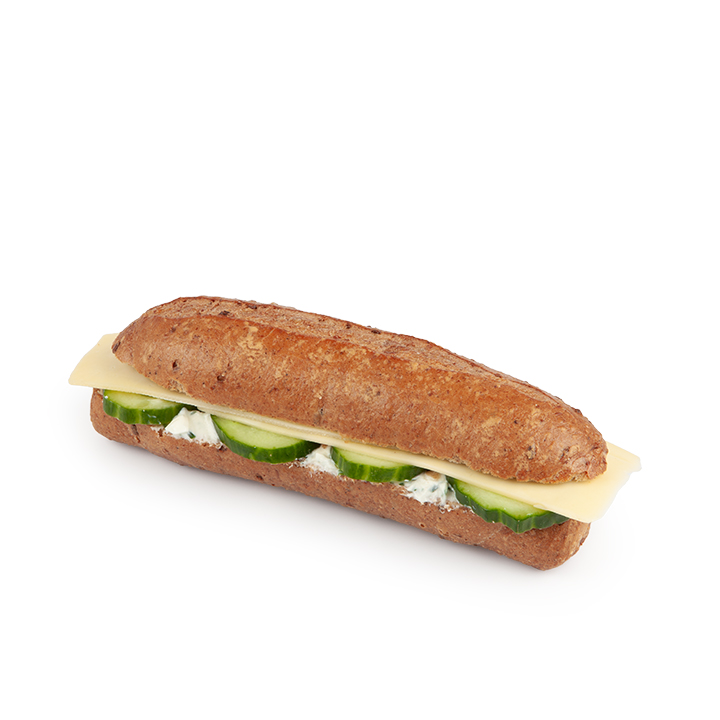 Ein Vollkornbrötchen, gefüllt mit Gurkenscheiben, cremigem Aufstrich und einer Scheibe Käse, dargestellt auf weißem Hintergrund.