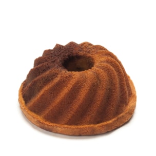 Ein goldbrauner Gugelhupf mit einem gewirbelten, geriffelten Muster steht auf einem weißen Hintergrund. Der Kuchen hat ein Loch in der Mitte und einen leicht knusprigen Rand.