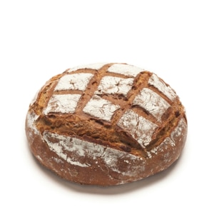 Ein runder, rustikaler Brotlaib mit einer knusprigen, goldbraunen Oberfläche und einem Mehlstaub auf der Oberseite, der ein kreuzförmiges Schnittmuster aufweist. Das Brot befindet sich auf einem schlichten weißen Hintergrund.
