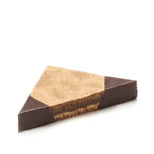 Ein dreieckiges Stück Schichtdessert mit einem mit Schokolade überzogenen Boden und zwei Ecken und einer hellbraunen, glatten oberen Schicht in der Mitte. Die Nachspeise wirkt reichhaltig und dicht.