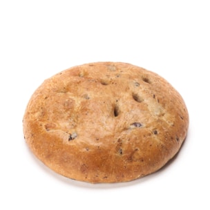 Ein runder, goldbrauner Brotlaib mit leicht gewölbter Oberfläche und kleinen dunklen Flecken auf weißem Grund.