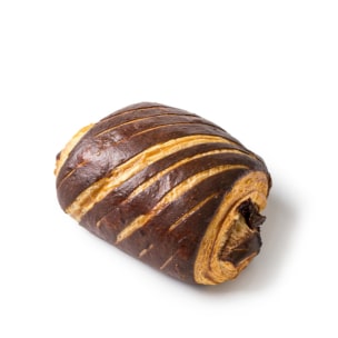 Ein Schokoladencroissant mit einer goldbraunen, gestreiften, flockigen Kruste liegt auf einem weißen Hintergrund.