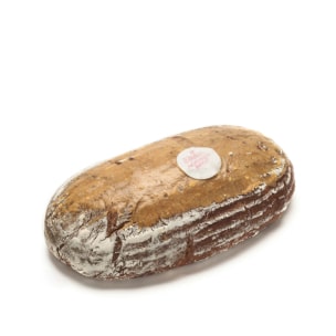 Ein Laib rustikales Brot mit einem Mehlstaub auf der Kruste und einem runden Etikett auf der Oberseite, auf weißem Hintergrund.