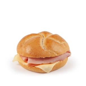 Ein einfaches Sandwich mit Schinken- und Käsescheiben in einem runden, leicht gebräunten Brötchen, dargestellt vor einem schlichten weißen Hintergrund.
