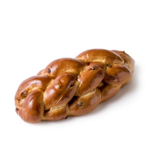 Ein geflochtener Laib Challah-Brot mit glänzender, goldbrauner Kruste, dargestellt auf weißem Hintergrund.