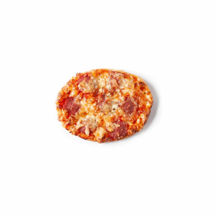 Eine kleine ovale Pizza, belegt mit geschmolzenem Käse und Peperoni-Scheiben, fotografiert auf einem einfachen weißen Hintergrund.