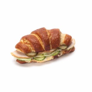 Ein Croissant-Sandwich, gefüllt mit Truthahnscheiben, Gurken und Essiggurken, auf weißem Hintergrund.