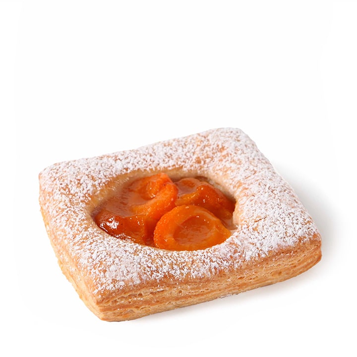 Ein mit Puderzucker bestreutes und mit glasierten Aprikosenscheiben gefülltes, quadratisches Plundergebäck auf weißem Grund.