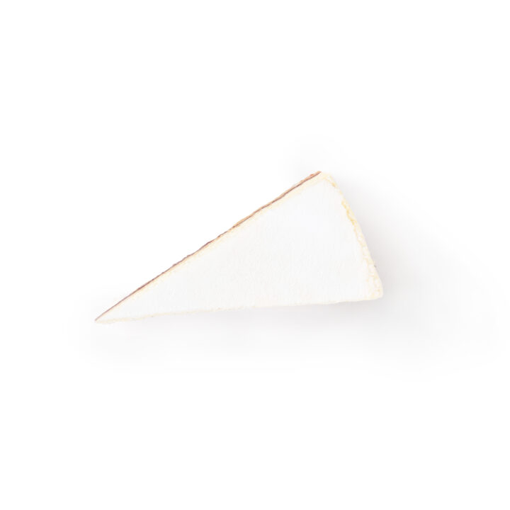 Ein einzelnes Stück einfacher Käsekuchen mit goldener Kruste, von oben auf weißem Hintergrund fotografiert.