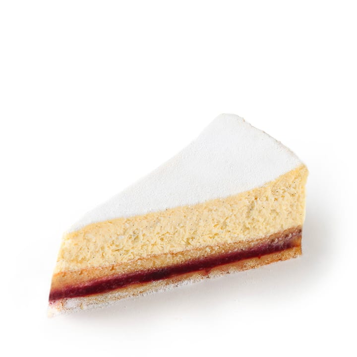 Ein einzelnes Stück geschichteter Käsekuchen mit einer Schicht Puderzucker auf der Oberseite und einer dünnen Schicht roter Fruchtfüllung in der Nähe des Bodens, vor einem weißen Hintergrund.