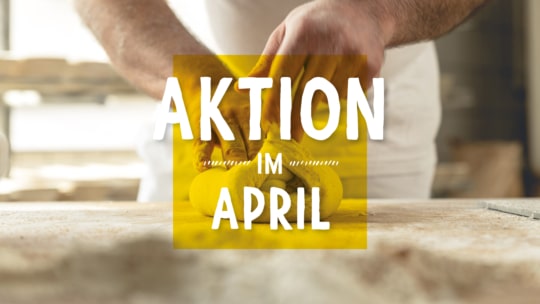 Eine Person knetet Teig auf einer bemehlten Fläche mit dem Text AKTION IM APRIL in fetten weißen Buchstaben über einem gelben Quadrat in der Mitte des Bildes.