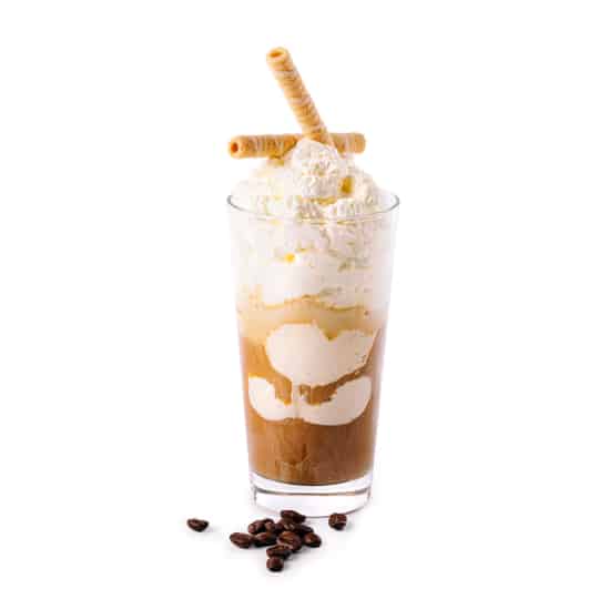 Ein Glas Eiskaffee mit Schlagsahne und zwei Waffelröllchen, auf deren Boden einige Kaffeebohnen verstreut sind, alles vor einem weißen Hintergrund.