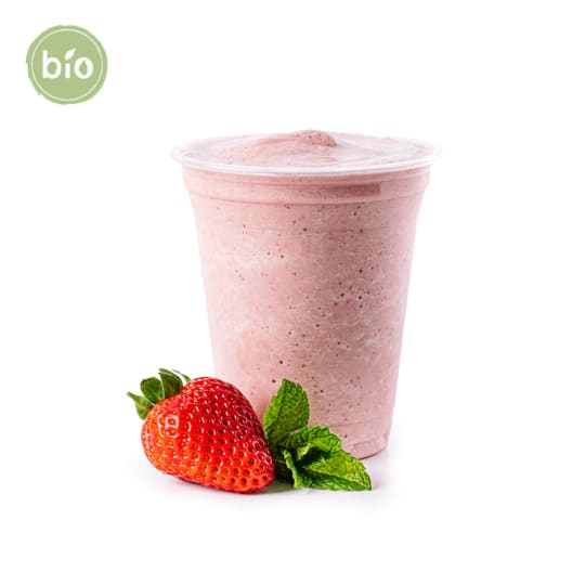 Ein Plastikbecher, gefüllt mit einem rosa Erdbeer-Smoothie, steht neben einer frischen Erdbeere und Minzblättern. In der oberen linken Ecke erscheint ein grünes Bio-Etikett, das anzeigt, dass es sich um ein Bio-Produkt handelt. Der Hintergrund ist weiß.