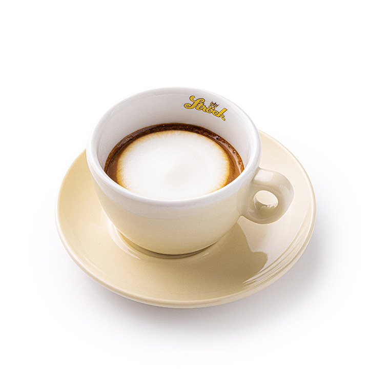 Eine beigefarbene Tasse mit Untertasse enthält einen Cappuccino mit aufgeschäumter Milch obenauf. Auf dem inneren Rand der Tasse ist das Wort Splendid aufgedruckt. Der Hintergrund ist einfarbig weiß.