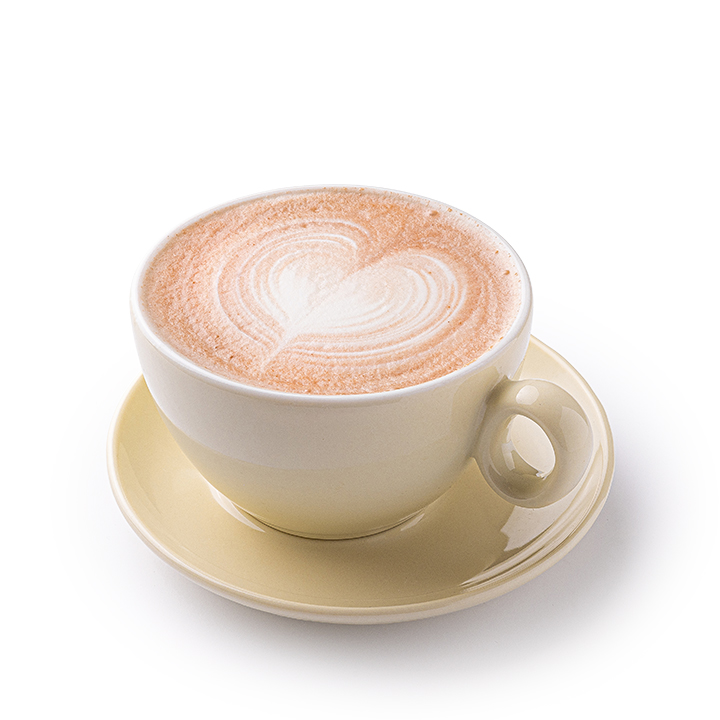 Eine Tasse Cappuccino mit herzförmigem Milchkaffee auf dem Schaum, serviert in einer beigen Tasse mit passender Untertasse vor weißem Hintergrund.