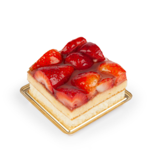 Ein quadratisches Stück Biskuit mit glasierten, halbierten Erdbeeren auf einem kleinen goldenen Tablett vor einem weißen Hintergrund.