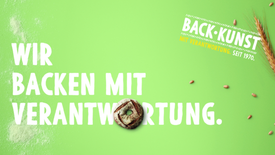 Grüner Hintergrund mit weißem Text in Deutsch: Wir backen mit Verantwortung. Ein rundes Gebäckstück ersetzt den Buchstaben O in Verantwortung. Rechts sind Weizenstängel und Körner zu sehen. Oben rechts: BACK KUNST mit Verantwortung, seit 1970.