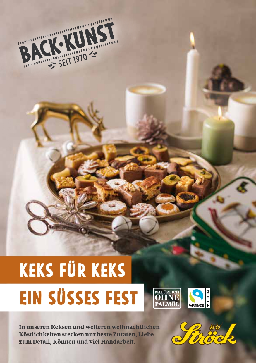Ein festlicher Tisch mit einem Tablett mit verschiedenen Keksen, Kerzen, einer goldenen Rentierfigur und Weihnachtsschmuck. Ein Teller mit Plätzchen steht im Vordergrund und schafft eine warme Weihnachtsatmosphäre. Der Text wirbt für die Bäckerei Ströck.