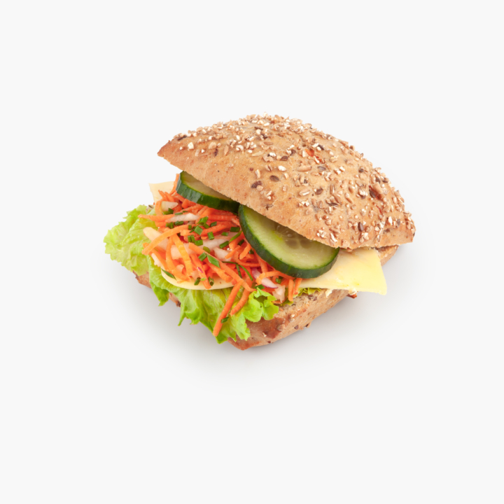A multigrain sandwich bun filled with lettuce, shredded carrots, cheese, cucumber slices, and fresh herbs, isolated on a white background.
