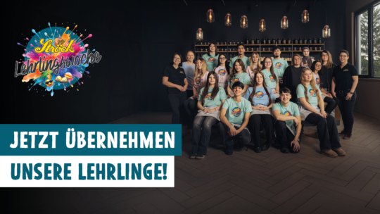 Eine Gruppe junger Leute in passenden türkisfarbenen T-Shirts posiert zusammen in einem modernen Raum. Auf dem bunten Logo links steht "Lehrlingswoche". Der Text auf Deutsch lautet: "JETZT ÜBERNEHMEN UNSERE LEHRLINGE!".