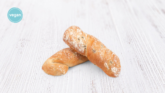 Zwei rustikale Brötchen, die mit etwas Mehl bestäubt sind, liegen auf einer weißen Holzfläche. In der oberen linken Ecke ist ein blaues, rundes Vegan-Label zu sehen.